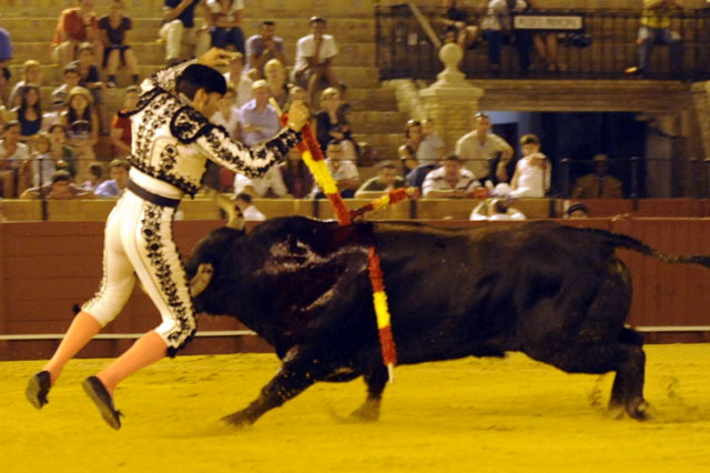 Levanta los brazos para adornarse pero el toro ya le ha cazado y empitonado. (FOTO: Sevilla Taurina)