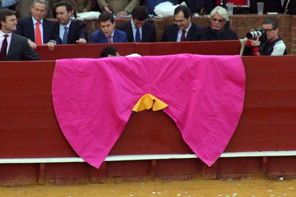 Un mozo de espadas aprovecha un intervalo entre toro y toro para limpiar las bambas de un capote. (FOTO: Javier Martínez)