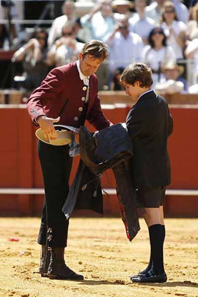 Antonio Domecq, tras su actuación esta mañana en la Maestranza, le entrega los zahones a su hijo en señal de retirada y herencia para una posible continuidad futura. (FOTOS: Arjona/lamaestranza.es)