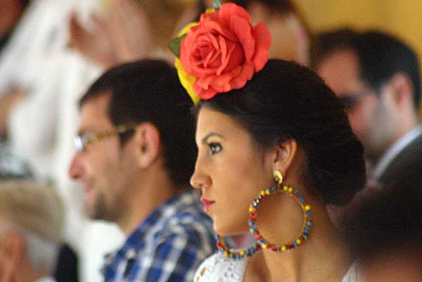 Los tedidos se llenan de mujeres guapas las tardes feriales. Una flamenca con dos flores 'bien plantá' en la cabeza. (FOTO: Javier Martínez)