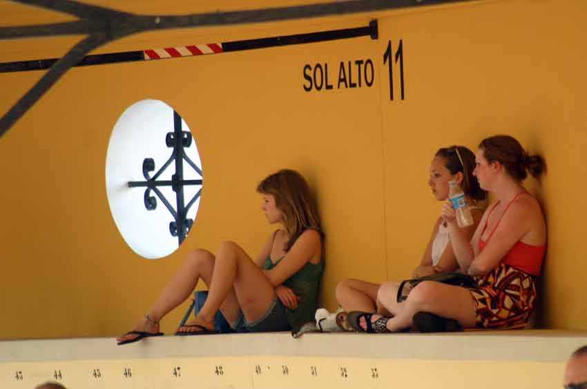 Las tres turistas de la última fila de la plaza, buscando la sombrita. (FOTO: Javier Martínez)