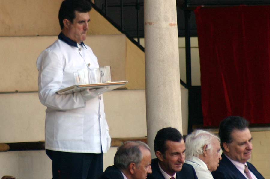 Un camarero retira los vasos de cristal en el palco particular de los maestrantes.