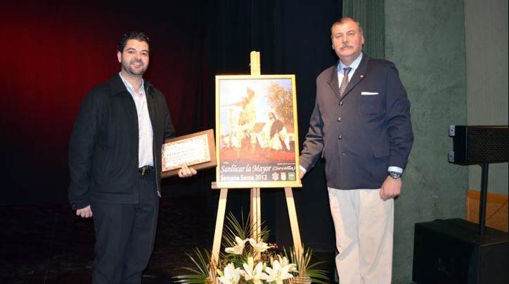 El fotógrafo taurino sevillano Eduardo López en la presentación del cartel de la Semana Santa de Sanlúcar la Mayor, con una fotografía de su obra.