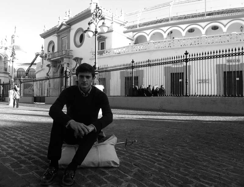 Una estampa que parece sacada de otra época: el aspirante a torero Paco Lama espera frente a la Maestranza con un hatillo que guarda espada y muleta. (FOTO: Javier Martínez)