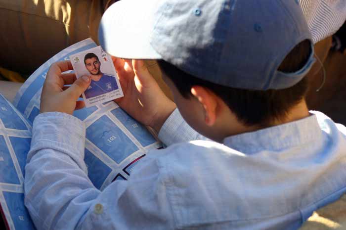 El crío se divirtió más con su álbum de cromos de fútbol.