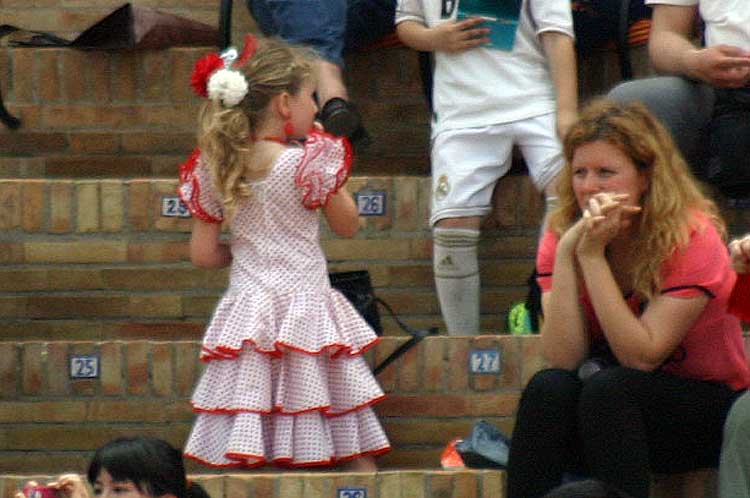 Y una joven aficionada que parece haber empalmado la Feria de Abril con la actual de Dos Hermanas.