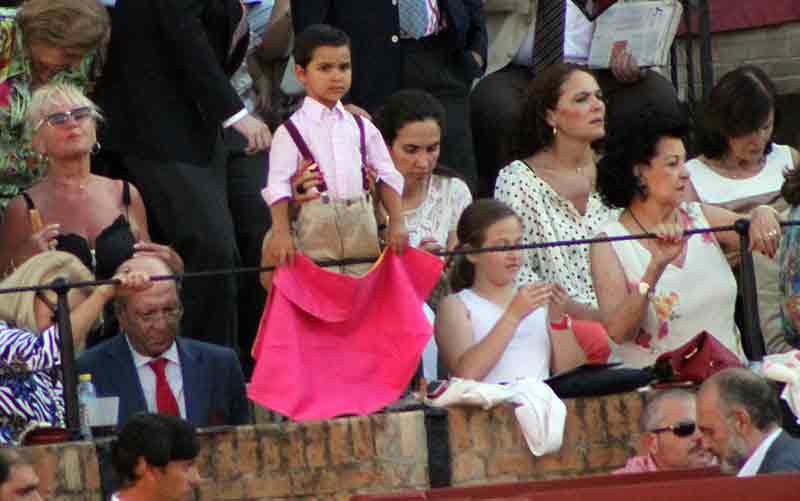 Un pequeño aficionado que quiere emular con su capotillo a los toreros que admira.