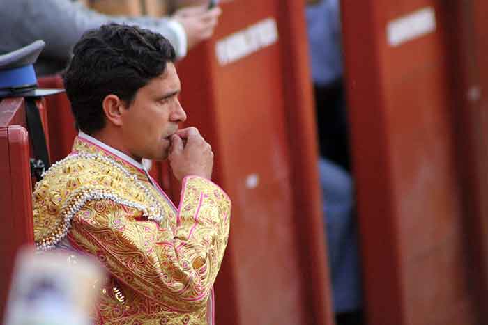 Un picador espera su turno comiendo pipas en el callejón.