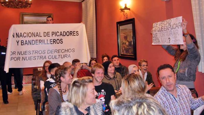 Pancartas a favor y en contra de los toros durante el pleno de Alcalá de Guadaíra. (FOTO: Alberto Mallado / Guadaíra Información)