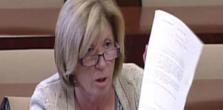 Lola Calderón muestra el documento de la Junta, firmado por el Jefe del Servicio de la Delegación, José Antonio Delgado, con los tres criterios que no aplica su propia delegada, Carmen Tovar. (FOTO: Parlamento de Andalucía)