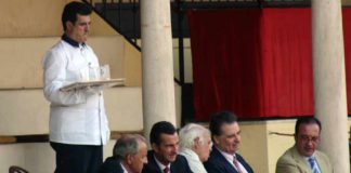 Un camarero con una bandeja con vasos de cristal junto a un grupo de maestrantes. (FOTO: Sevilla Taurina)