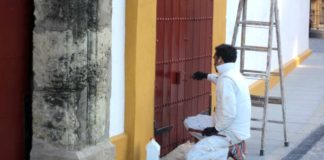 Un operario repasa de pintura una puerta de acceso a la plaza de Sevilla. (FOTO: Javier Martínez)