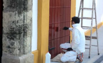 Un operario repasa de pintura una puerta de acceso a la plaza de Sevilla. (FOTO: Javier Martínez)