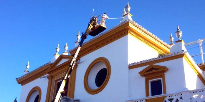 Operarios retocan con una grúa el tejadillo de la Puerta del Príncipe. (FOTO: Javier Martínez)