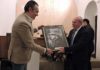 Roberto Rodríguez Gutiérrez recibe de manos del presidente del Círculo Cultural Taurino el primer premio del 'II Certamen literario taurino' de Osuna.