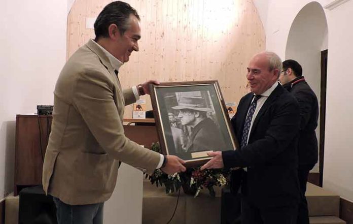 Roberto Rodríguez Gutiérrez recibe de manos del presidente del Círculo Cultural Taurino el primer premio del 'II Certamen literario taurino' de Osuna.